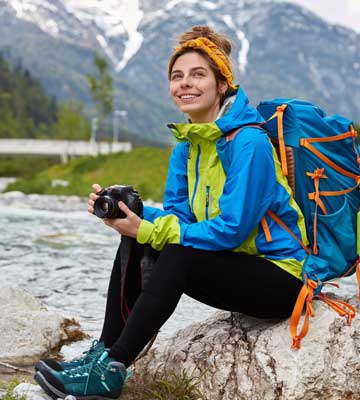 Woman with Camera on mountain backpacking trip