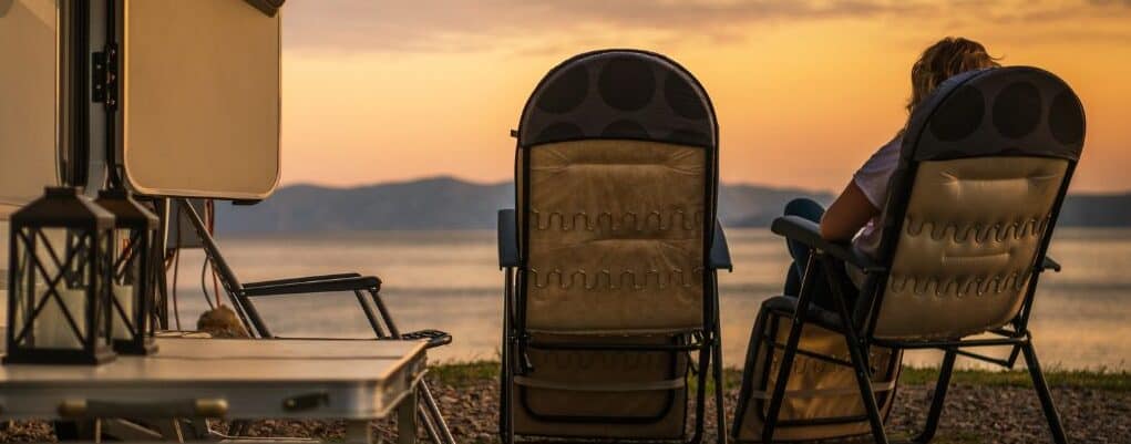 outdoor lifestyle relaxing outside an rv by a lake